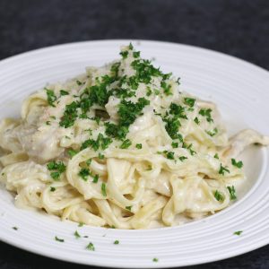 Homemade chicken alfredo garnished with fresh parsley