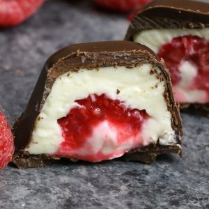 Raspberries Stuffed in smooth and creamy mini cheesecake bites, and then covered by chocolate. The ice cube tray makes it so easy and fun to make! All you need is a few simple ingredients: raspberries, chocolate, cream cheese, sugar, vanilla and whipped cream. An easy recipe that makes a great finger food dessert for parties, brunch, Mother’s Day or as an afternoon snack! Party food, no bake, party dessert recipes. Video recipe.