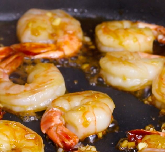 Closeup photo of jumbo shrimp being sauteed in a skillet when making Honey Garlic Shrimp Stir Fry