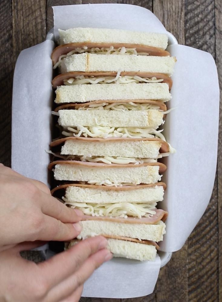 Layers of bread, ham and cheese in a loaf pan