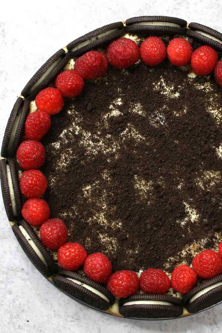 The Ultimate Oreo Cheesecake – the easiest and most beautiful cake topped with cookies and cream crumbs and fresh raspberries. All you need is a few simple ingredients: oreo cookies, cream cheese, sugar, vanilla, eggs, sour cream and raspberries. Great for dessert, brunch, birthday parties or Mother’s Day. Video recipe. | tipbuzz.com