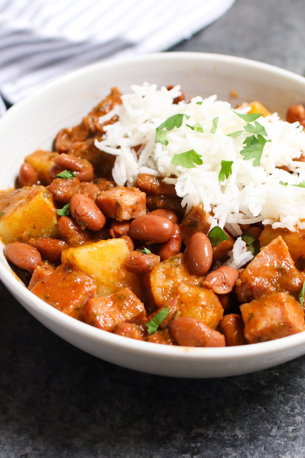 Puerto Rican Rice and Beans are thick, creamy and flavorful! The tender beans are simmered in a sofrito and tomato based sauce, then served over rice. It’s a Puerto Rican staple, also known as Habichuelas Guisadas or stewed beans.