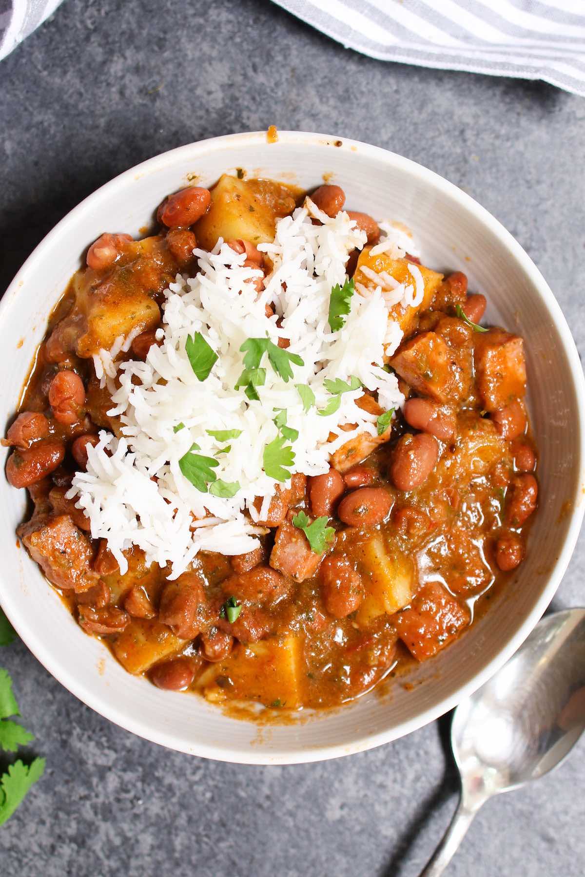 Puerto Rican rice and beans served in a white bowl and sprinkled with chopped cilantro